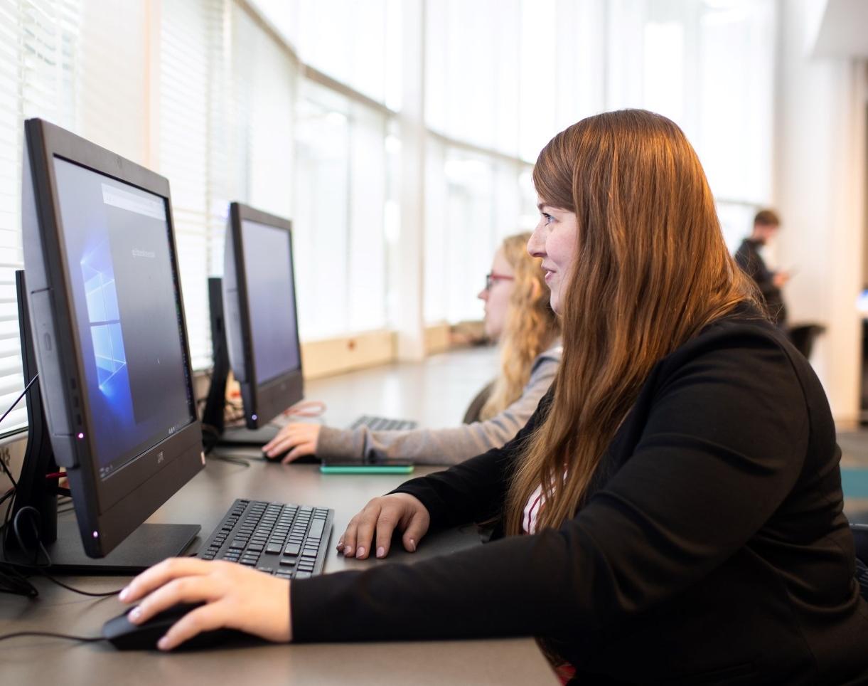 A girl at a computer clicking a mouse