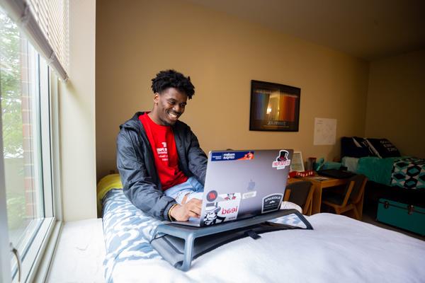 Student studying on their bed in the dorm